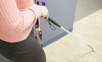 White cane user walking down a hallway White cane user walking down a hallway
