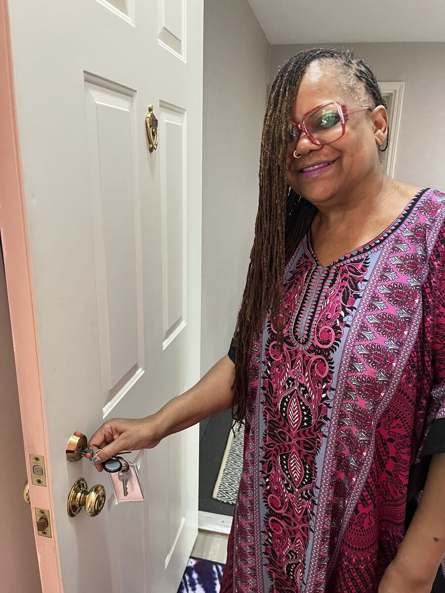 Rosie puts her keys in the front door of her apartment and smiles for the camera